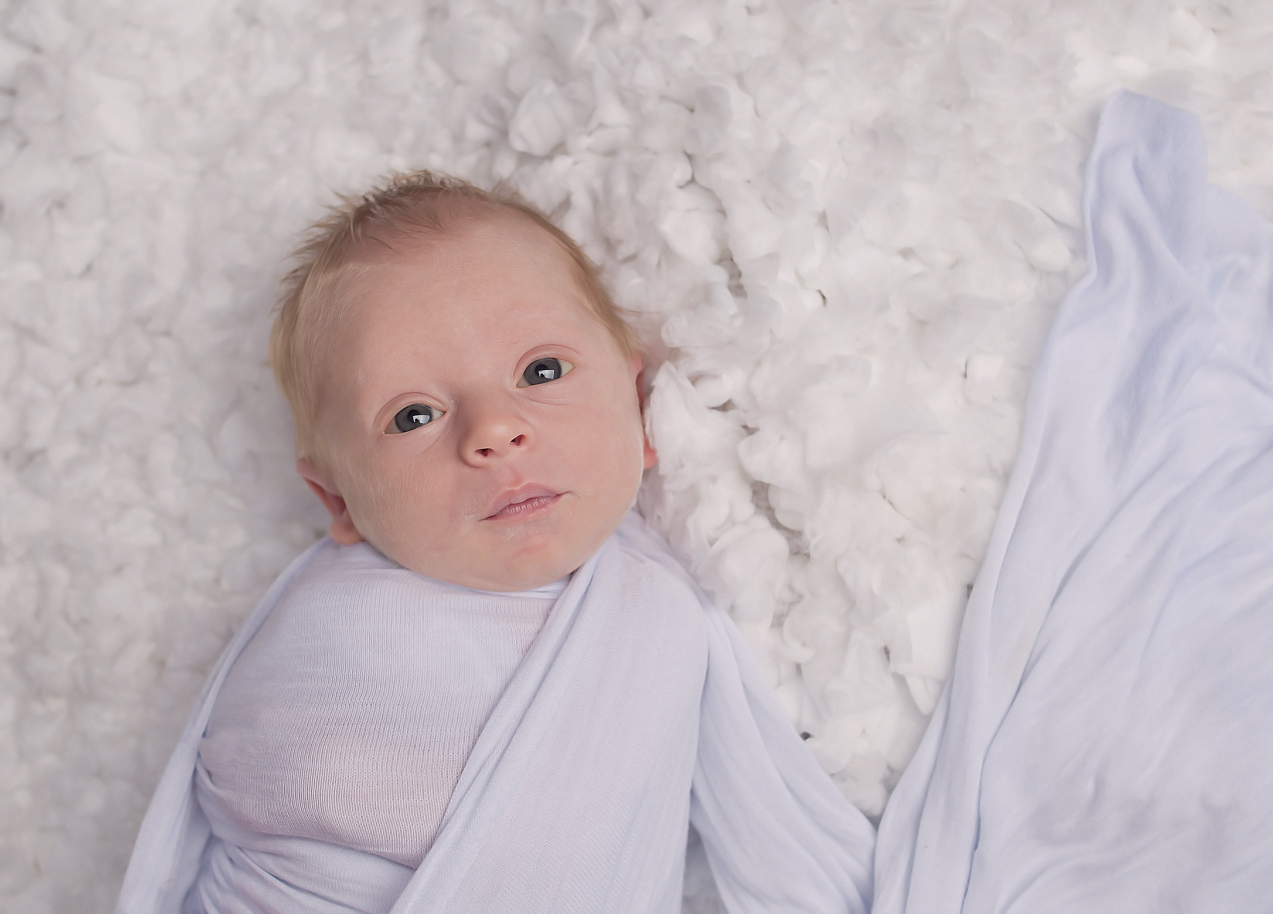 Baby laying on rug in white wrap Nashville Tennessee