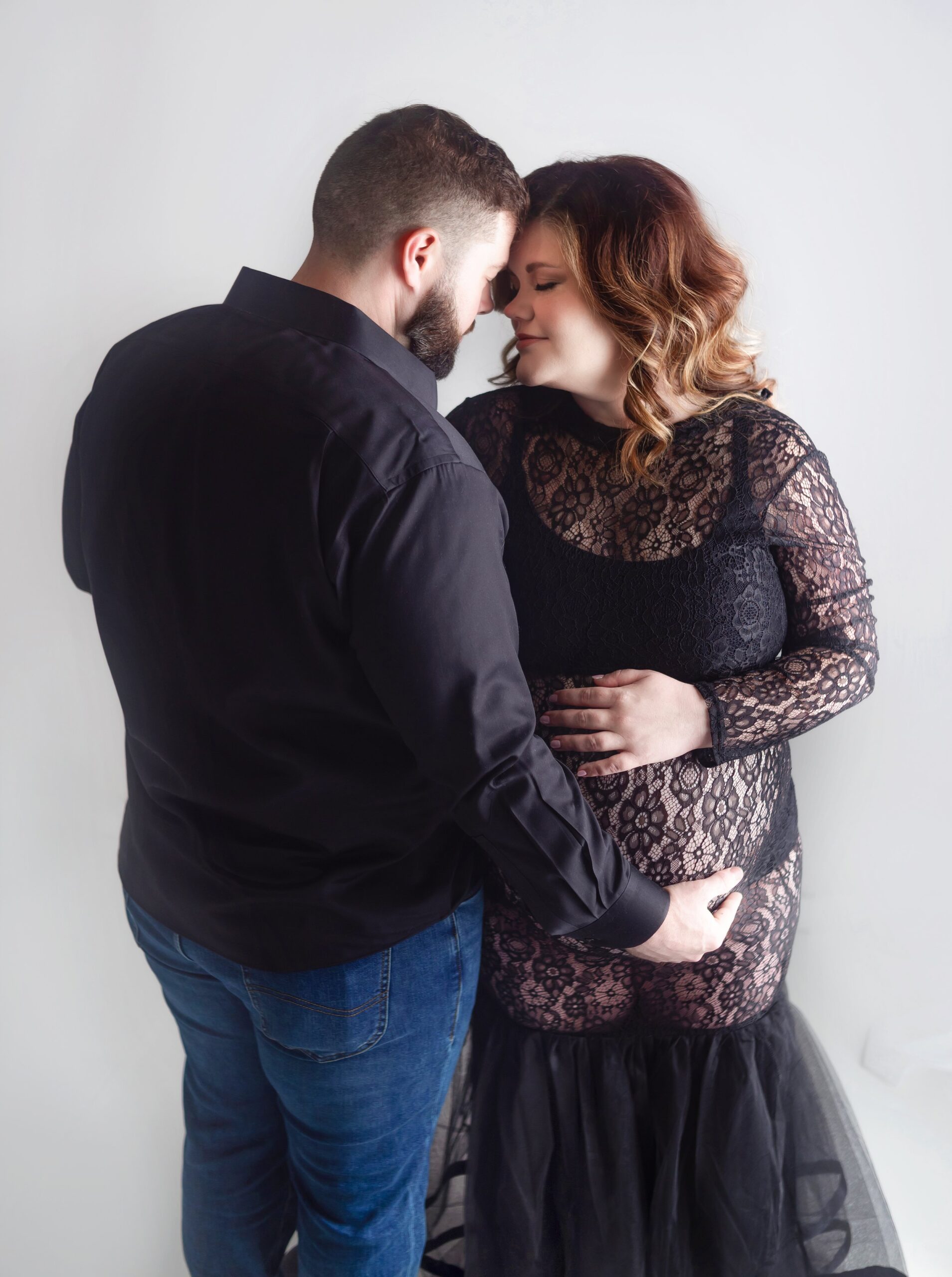 man and women hugging, women wearing black gown during maternity photoshoot in brentwood tennessee photography studio