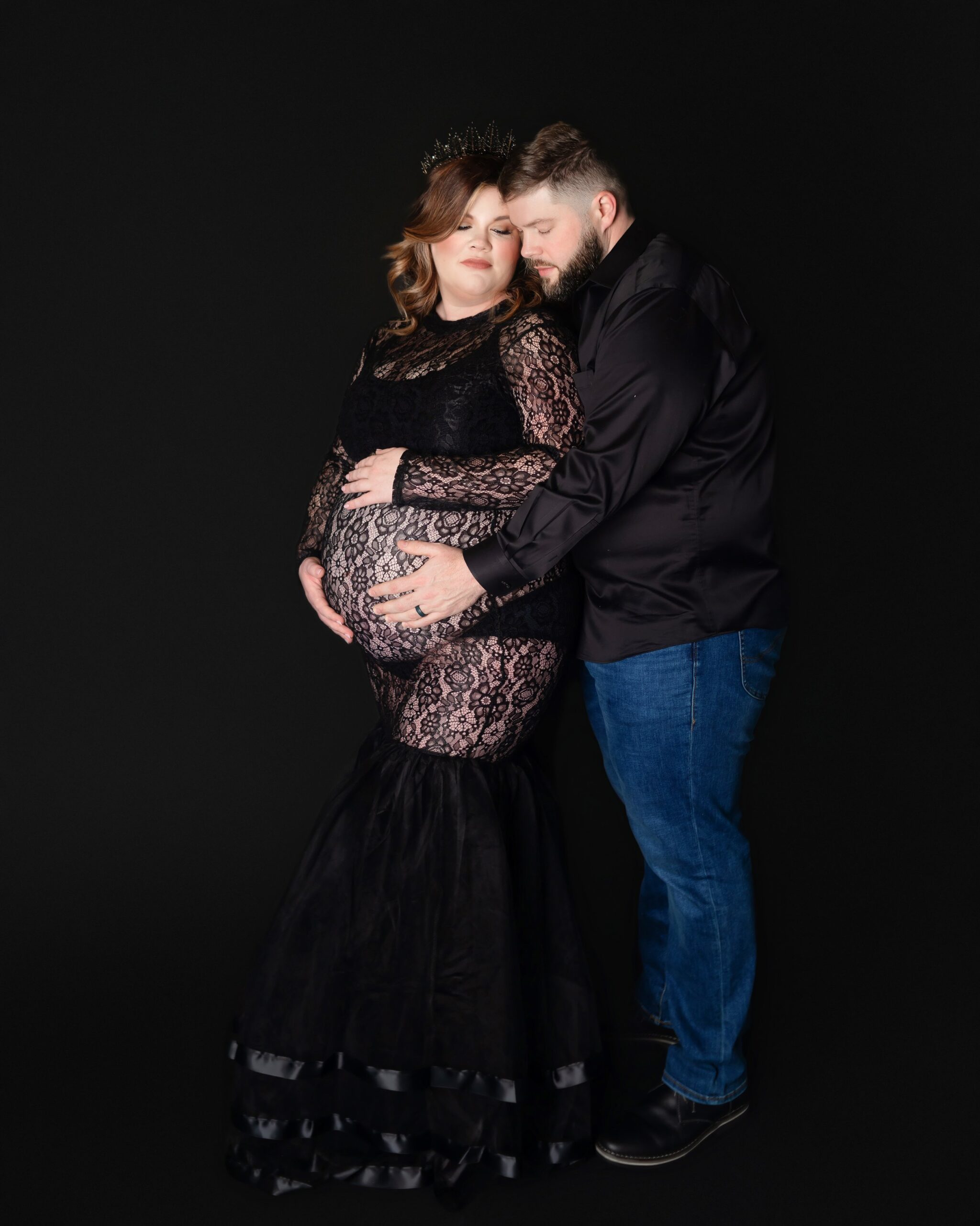women wearing black gown, man holding her belly during maternity photoshoot, in brentwood tennessee photography studio, near me