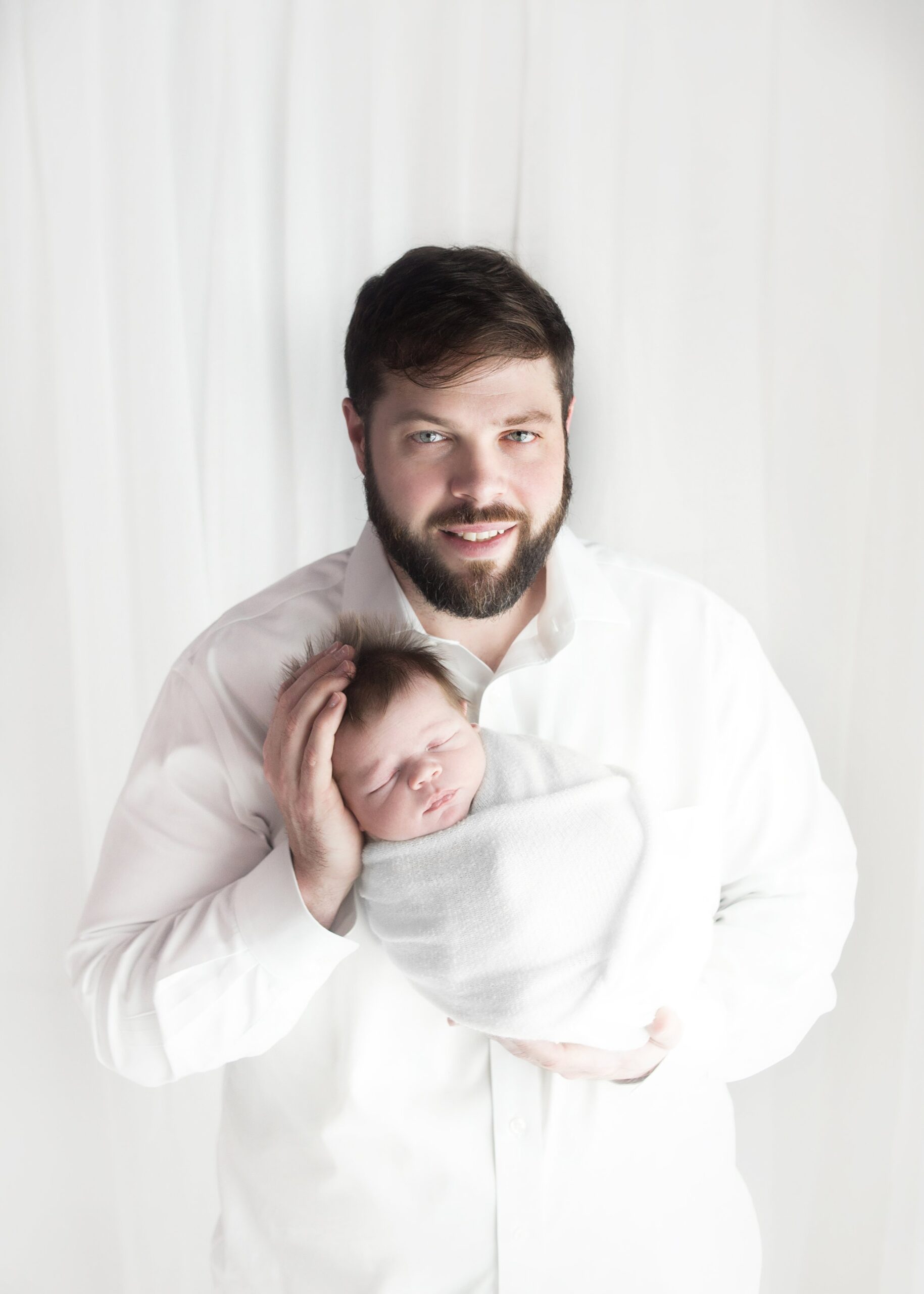 dad holding newborn baby, during newborn photoshoot, in brentwood tennessee photography studio