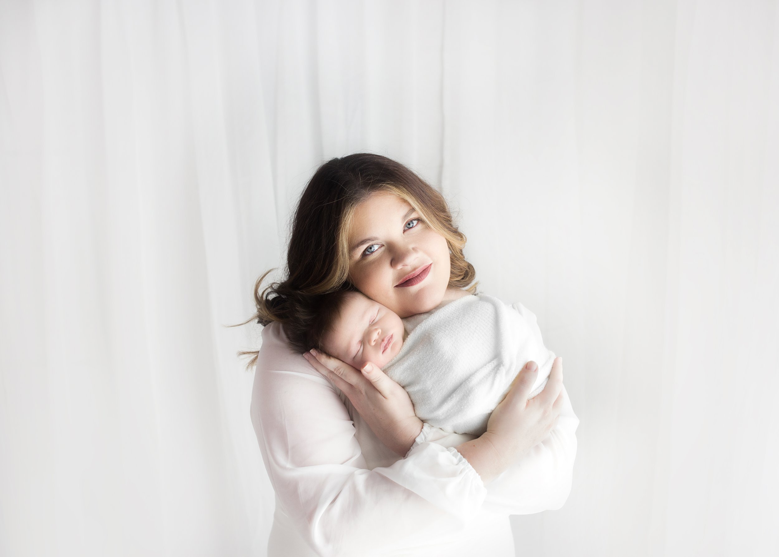 mom holding newborn baby during newborn photoshoot in mount juliet photography studio, near me