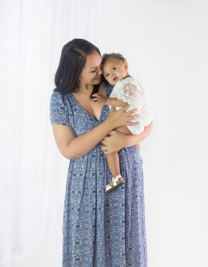 Mom wearing blue dress, holding daughter during family photoshoot in Mount Juliet Tennessee photography studio 