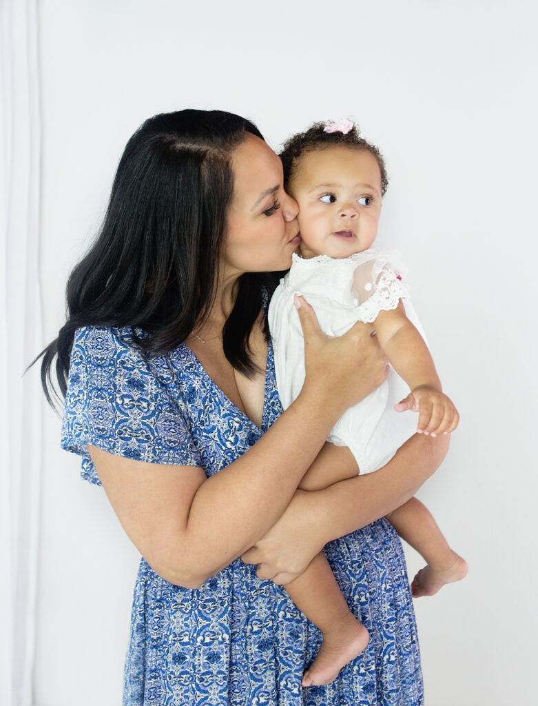 Mom kissing her daughter during family photoshoot in Franklin Tennessee photography studio 