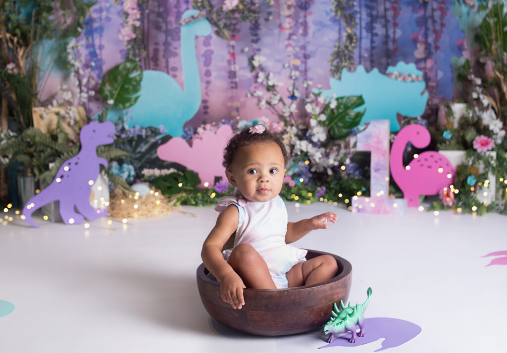 baby girl sitting in a wood bowl during cake smash photoshoot in Mount Juliet Tennessee photography studio 