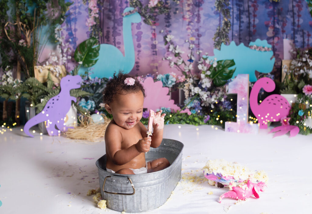 Little girl eating cake, sitting in little tub during cake smash photoshoot in Mount Juliet Tennessee photography studio 