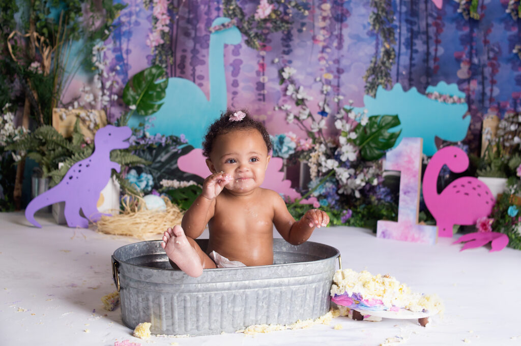 Little girl with her foot out of the little tub sitting in tin during cake smash photoshoot in Mount Juliet Tennessee photography studio 