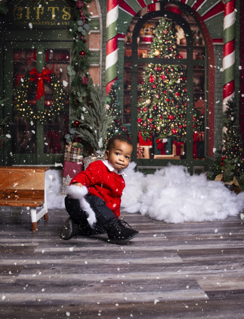 Little boy wearing red sweater holding fake snow during Christmas mini session photoshoot with Mount Juliet, TN Photographer 