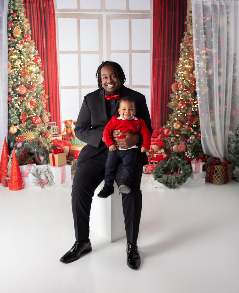 Brother holding little brother dressed for Christmas during Christmas Mini session in Nashville, TN in Mount Juliet, TN photography studio 