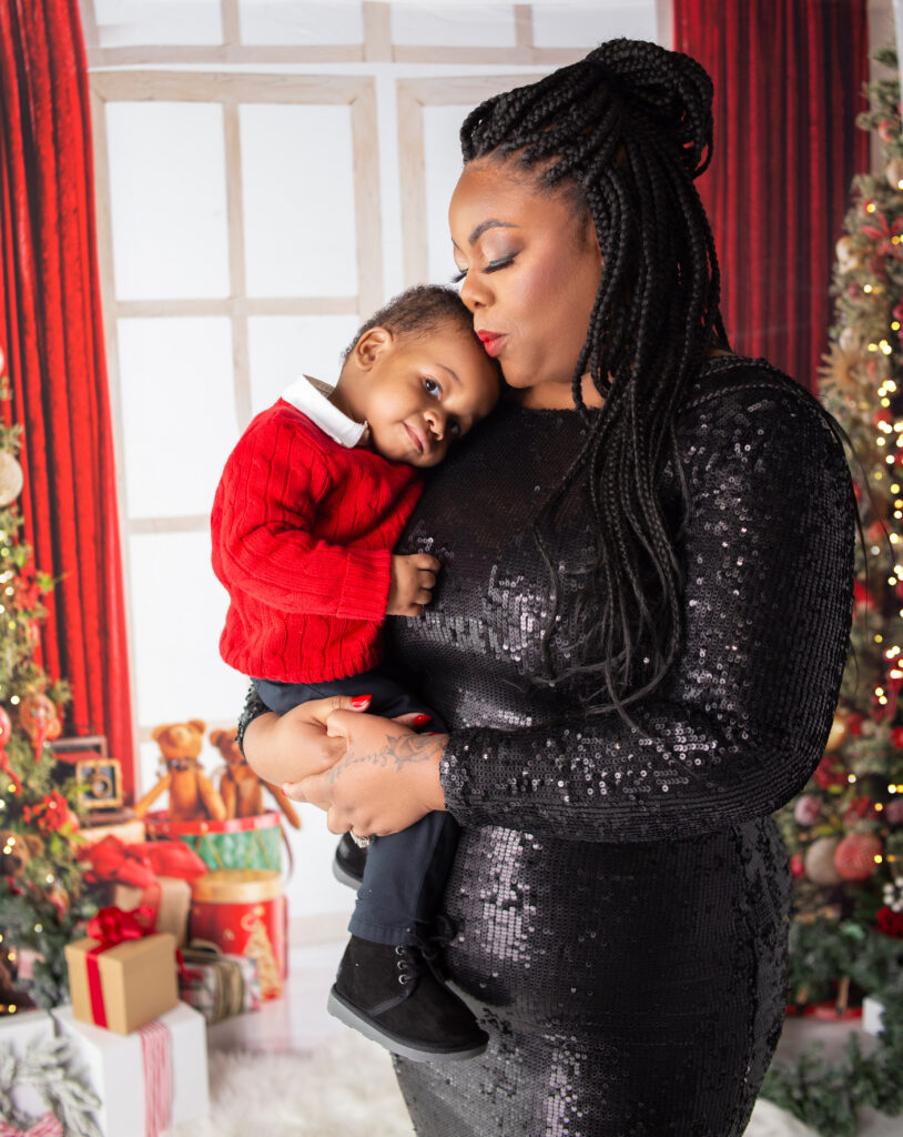 Mom kissing son on the head during Christmas Mini session photoshoot in Mount Juliet, TN Photography studio with Nashville, TN photographer 