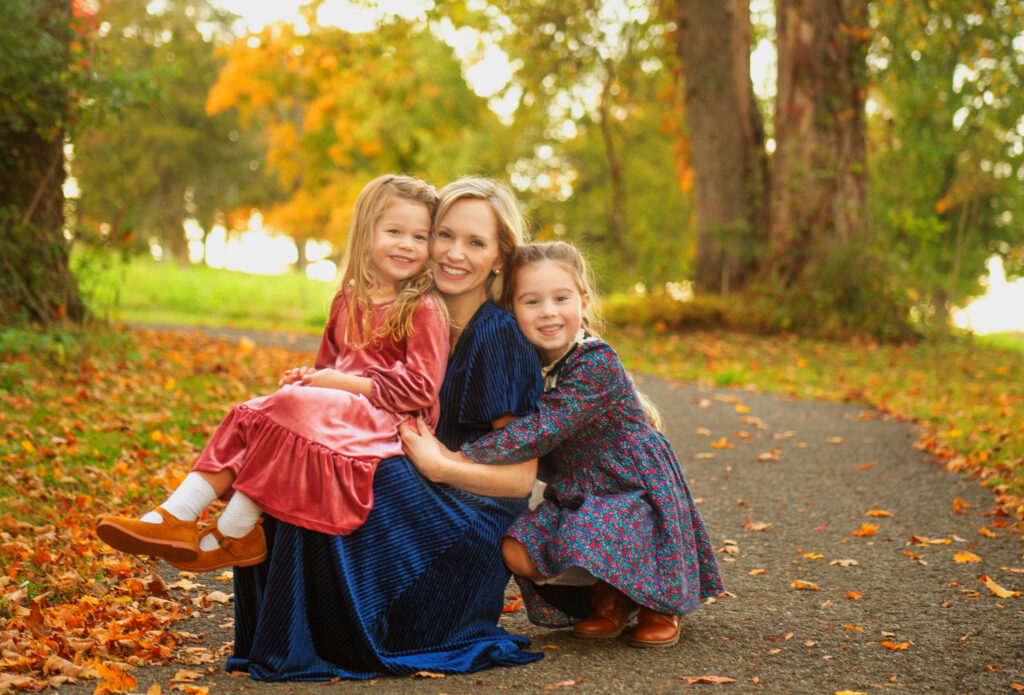 Mom hugging her daughters during fall mini session photoshoot with Nashville, TN photographer in Mt. Juliet park 