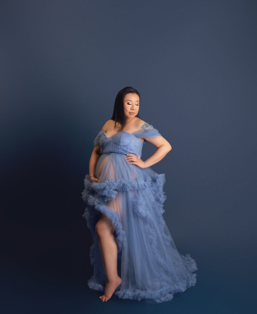 Nashville, TN photographer capturing pregnant women during maternity photoshoot wearing blue glam gown 